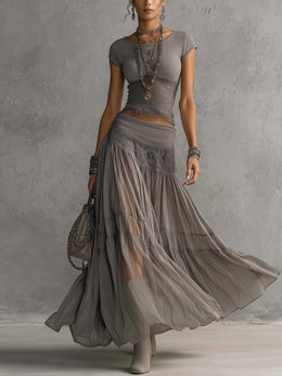 Completo grigio con top in pizzo e gonna plissettata